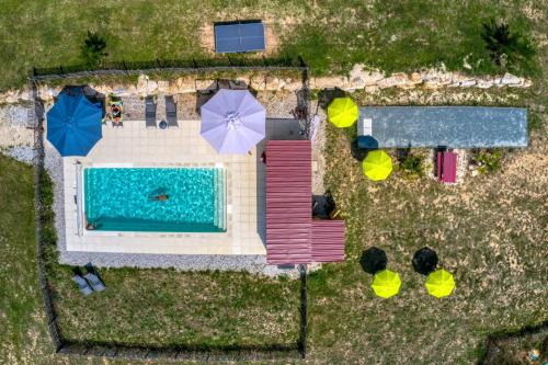an overhead view of a swimming pool with umbrellas at JOINS! Glamping Aquitaine in Saint-Aigne