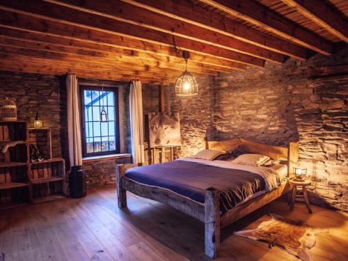 a bedroom with a bed and a stone wall at Holiday home in Bastogne with bubble bath in Bastogne