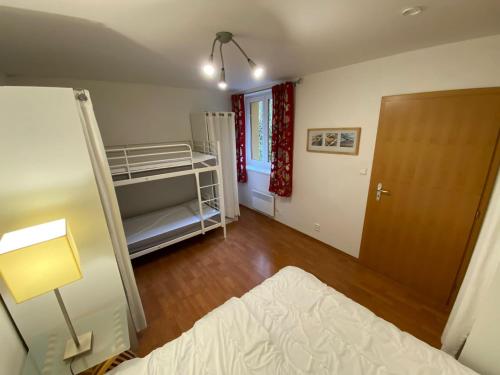 a bedroom with a bed and a lamp and a door at Apartman Poustevnik in Pec pod Sněžkou