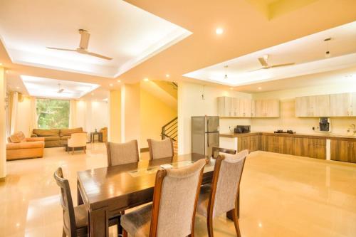 a kitchen and dining room with a table and chairs at Luxury 3BHK Villa with Private Swimming Pool near Candolim in Marmagao