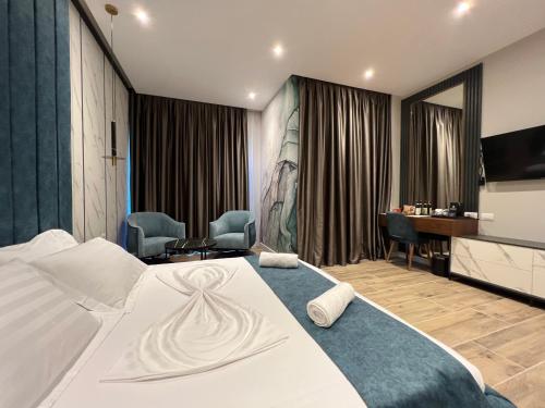 Pokój hotelowy z łóżkiem i biurkiem w obiekcie Domus Hotel & Apartments w mieście Shëngjin