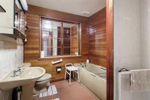 a bathroom with a tub and a sink and a toilet at Bungalow in Spey Bay, Moray (Disabled Accessible) in Kingston