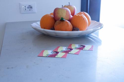 a bowl of fruit with apples and oranges on a table at Suite Dantè - Typical Apulian Rooms in Cisternino