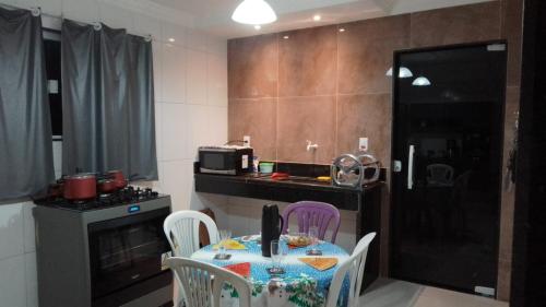eine kleine Küche mit einem Tisch und Stühlen in einem Zimmer in der Unterkunft Casa e área Gourmet. Cardoso Moreira-RJ in Cardoso Moreira