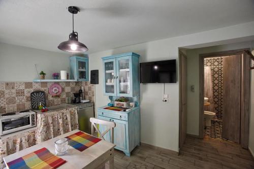 a kitchen with blue cabinets and a table in it at Kadmilos suites Samothraki in Samothraki