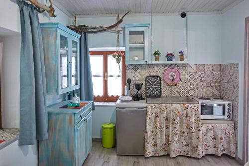 eine Küche mit einer Spüle und einer Mikrowelle in der Unterkunft Kadmilos suites Samothraki in Samothráki