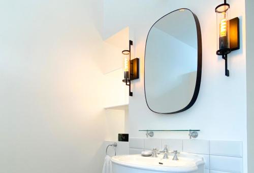 a bathroom with a sink and a mirror at La Garçonniere in Saint-Pierre