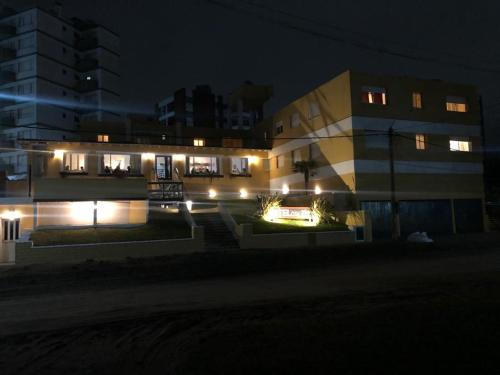 a building with lights in front of it at night at City mar playa in Villa Gesell