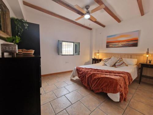 a bedroom with a bed and a ceiling fan at Casa Rincon a detached two bed cottage in Lubrín