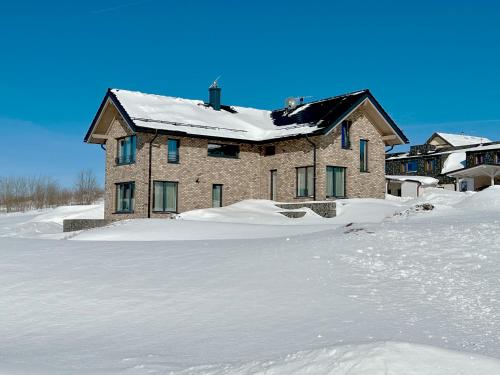 a house with a snow covered roof in the snow at VILLA BOHEMIA - Boží Dar in Boží Dar