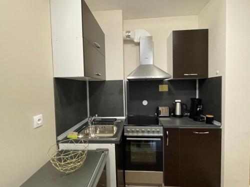 een kleine keuken met een wastafel en een fornuis bij Apartment E23 Borovets Gardens in Borovets