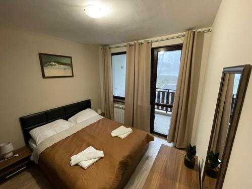 a bedroom with a bed with two towels on it at Apartment E23 Borovets Gardens in Borovets