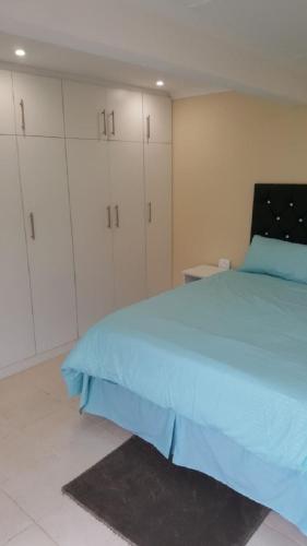 ein Schlafzimmer mit einem blauen Bett und weißen Schränken in der Unterkunft 24 Outeniqua Bluff Outeniqua Strand Glentana x 3 Units in Outeniqua Strand