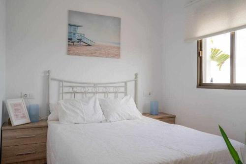 1 dormitorio con cama blanca y ventana en Ocean view, en Los Caños de Meca