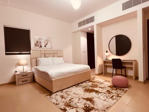 ONE 2BHK Elegant Apartment in Muscat Bay 03 في مسقط: غرفة نوم بسرير ومكتب ومرآة