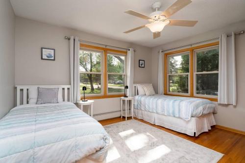 a bedroom with two beds and a ceiling fan at Manor on the River/Hot Tub/Pontoon/Jet Ski in Champlin