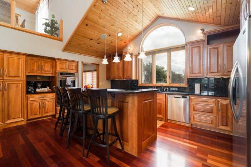 a kitchen with wooden cabinets and a island with bar stools at Manor on the River/Hot Tub/Pontoon/Jet Ski in Champlin