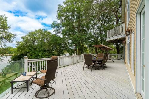 a deck with chairs and a table and an umbrella at Manor on the River/Hot Tub/Pontoon/Jet Ski in Champlin
