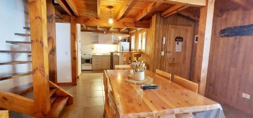 una mesa de madera en una habitación con cocina en Los Molinos San Martin de los Andes en San Martín de los Andes