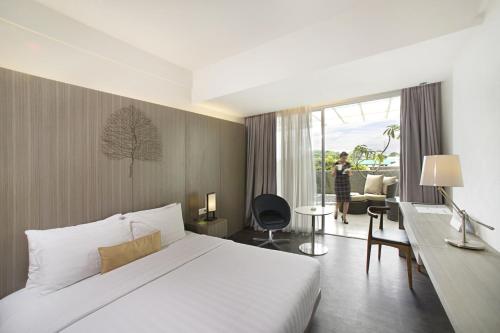 A bed or beds in a room at Grand Zuri Cikarang Jababeka