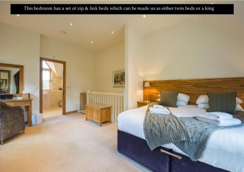 a bedroom has a large bed with a wooden headboard which can be made as at Mains of Taymouth Country Estate 5* Maxwell Villas in Kenmore