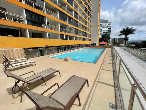 巴西利亞的住宿－MIX APART Hotel，一个带长椅的游泳池和一座建筑