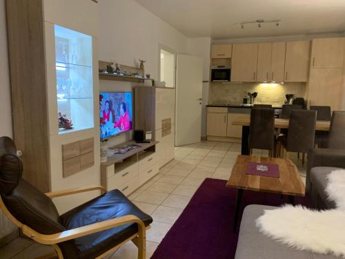 a living room and kitchen with a couch and a television at Almlodge Flachau in Flachau
