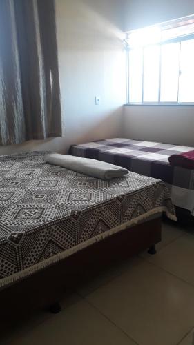 two beds sitting next to each other in a room at Porto apartamento in Porto Seguro