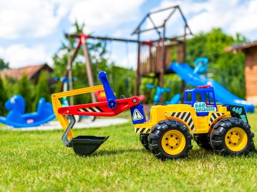 a toy dump truck on the grass in front of a playground at Wikno Port in Wikno