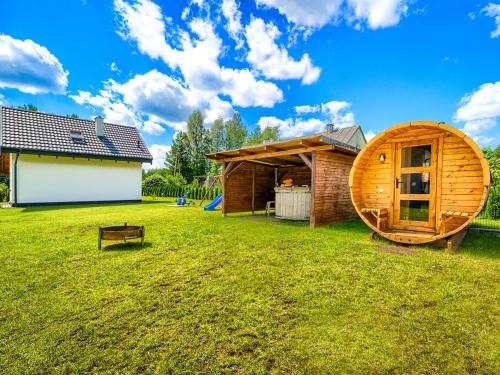 a large yard with a wooden circular house at Wikno Port in Wikno