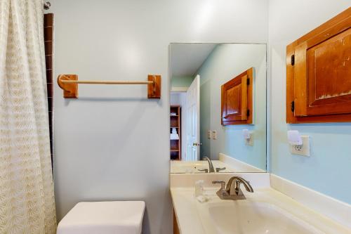 a bathroom with a tub and a sink and a mirror at Sugar Hill Delight in White River Junction