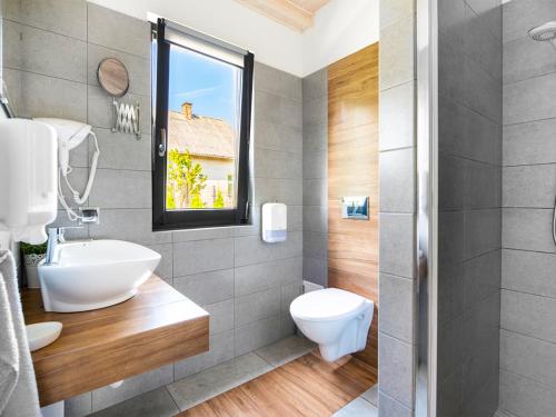 a bathroom with a toilet and a sink and a window at Wikno Port in Wikno