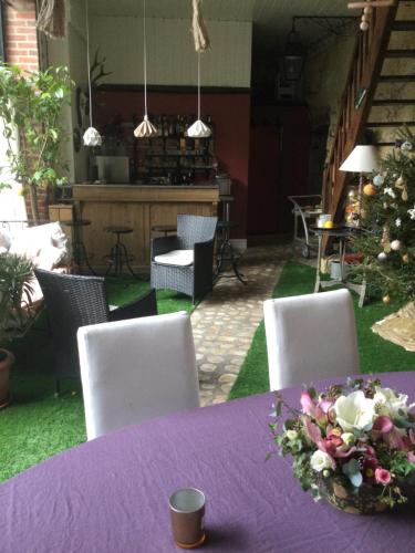 a table with a purple table cloth and flowers on it at Troglodytes "Loire Sauvage" (SPA) in Rochecorbon