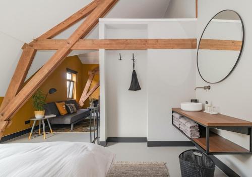 Cette chambre comprend un lit et un miroir. dans l'établissement B&B De Oude Dorpsslagerij, à Nuth