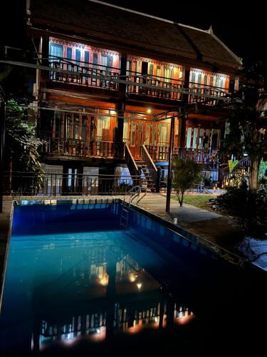 a building with a swimming pool at night at NamKhan Riverside in Luang Prabang