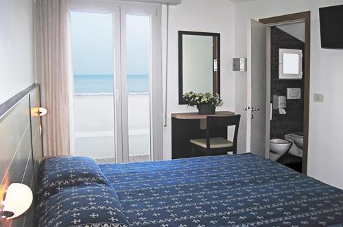 a bedroom with a blue bed with a view of the ocean at Hotel Sorriso - molto più di una stella in Riccione