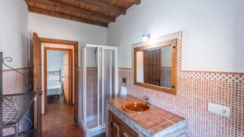une salle de bain avec un lavabo et un miroir dans l'établissement Casa El Cerro El Borge by Ruralidays, à Borge