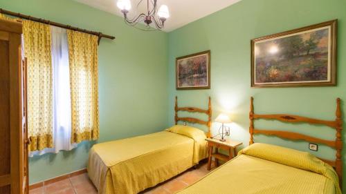 two beds in a room with green walls at Alojamiento Rural El Salto Villafranca de Córdoba by Ruralidays in Córdoba