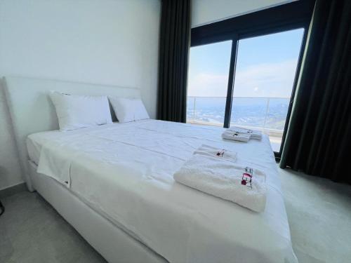 1 dormitorio con cama blanca y ventana grande en Villa with Private Pool and Terrace in Alanya en İshaklı