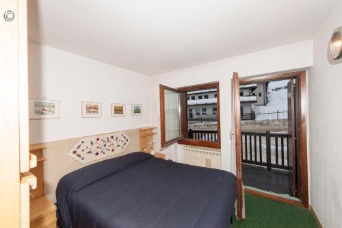 1 dormitorio con 1 cama y balcón en Breuil Cervinia Funicular House with Private Garage, en Breuil-Cervinia