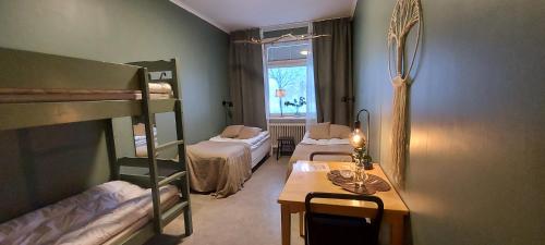 Cette chambre comprend 2 lits superposés, un bureau et une table. dans l'établissement Piteå Vandrarhem, à Piteå