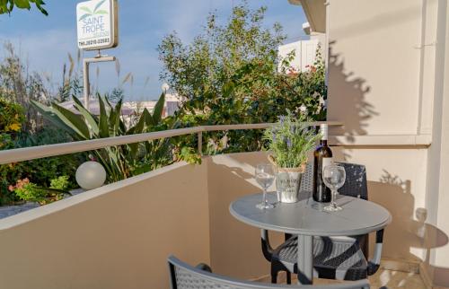 a table with wine bottles and glasses on a balcony at Saint Trope Studios in Kalamaki Chanion