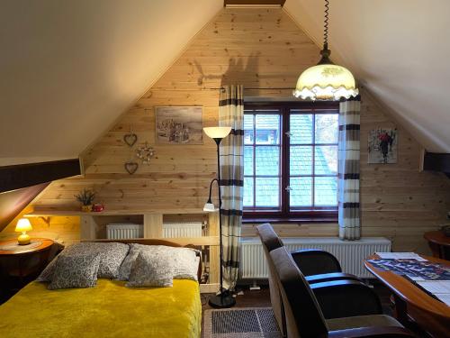 a bedroom with a yellow bed in a attic at Apartamenty i pokoje Domino in Karpacz