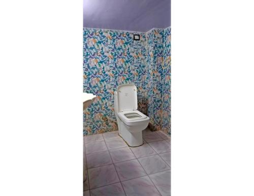 y baño con aseo y papel pintado con motivos florales. en Hotel Rajratan, Kanpur, en Collectorganj