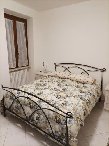 a bed with a floral comforter in a bedroom at Civico 46 in Foligno