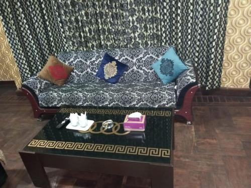 a couch with pillows and a table in a living room at Royal Luxury Hotel Lahore in Lahore