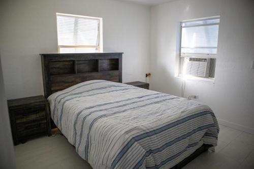 a bedroom with a bed and two windows at Pet Friendly Half-Duplex, Cottage with 40' Slip Option at The Boat House Marina in Marathon