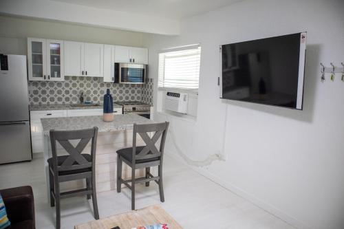 a kitchen with a table and two chairs and a television at Pet Friendly Half-Duplex, Cottage with 40' Slip Option at The Boat House Marina in Marathon