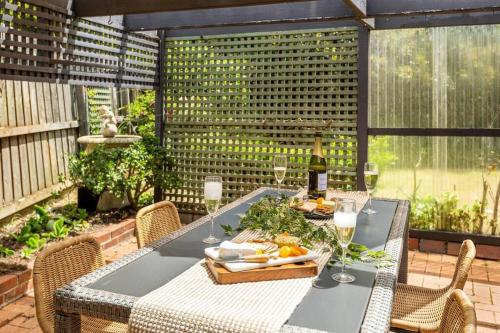 a table with a bottle of wine on a patio at Close to Geelong 4 Bedroom home by Short & Long Stays in Belmont