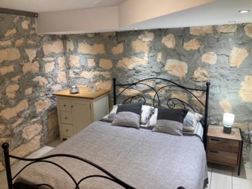 een slaapkamer met een bed en een stenen muur bij Villa Pascale in Chersonissos